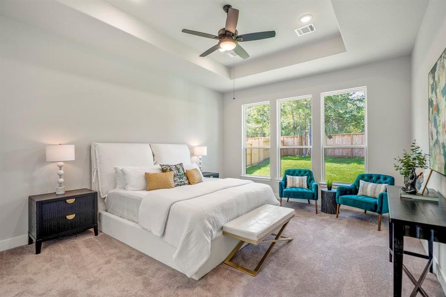 Wake up to serene views and abundant natural light in this spacious, quality-built  primary bedroom.