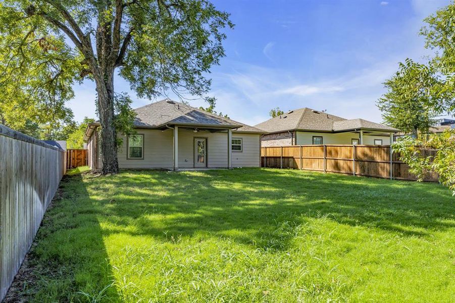 Rear view of house featuring a lawn