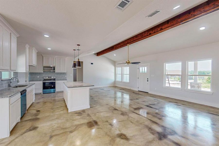 Kitchen with white cabinetry, a center island, appliances with stainless steel finishes, and a wealth of natural light