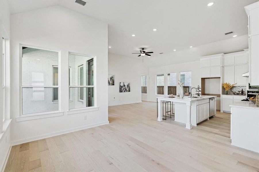 Kitchen with white cabinetry, a kitchen island with sink, and light wood-type flooring