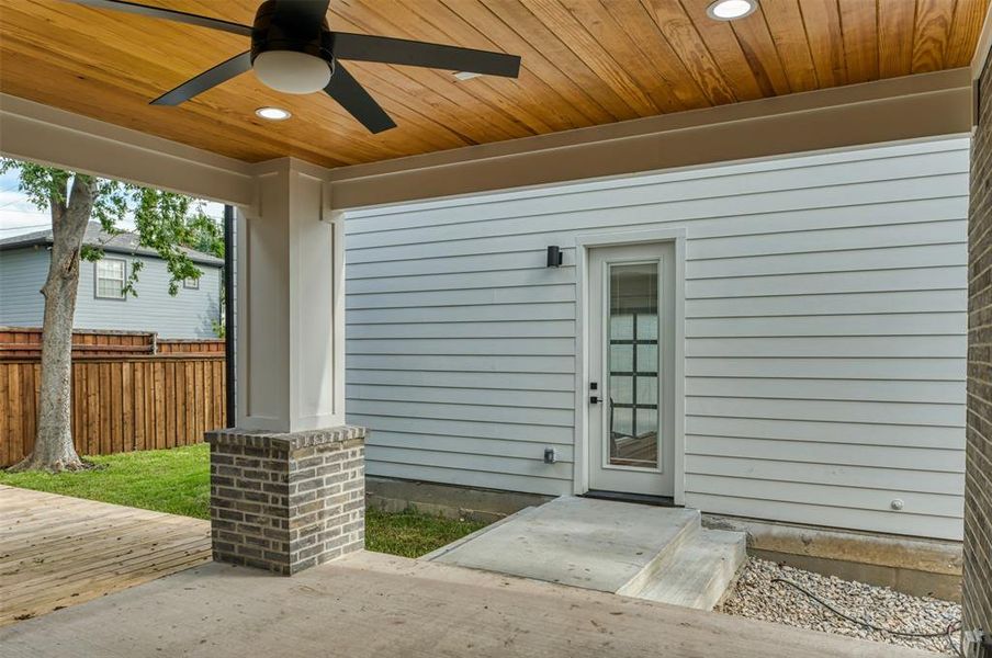 View of exterior entry with ceiling fan and a patio area