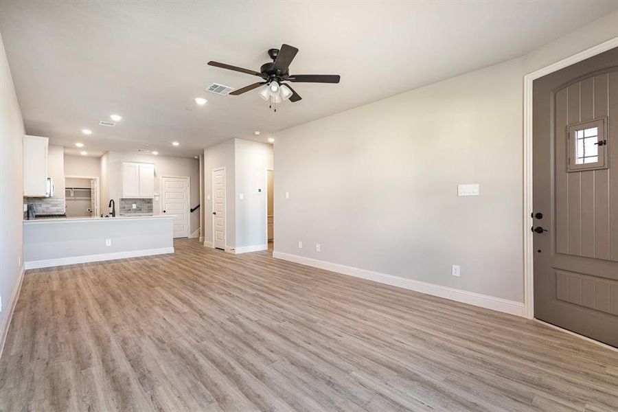 Unfurnished living room with light hardwood / wood-style floors, sink, and ceiling fan