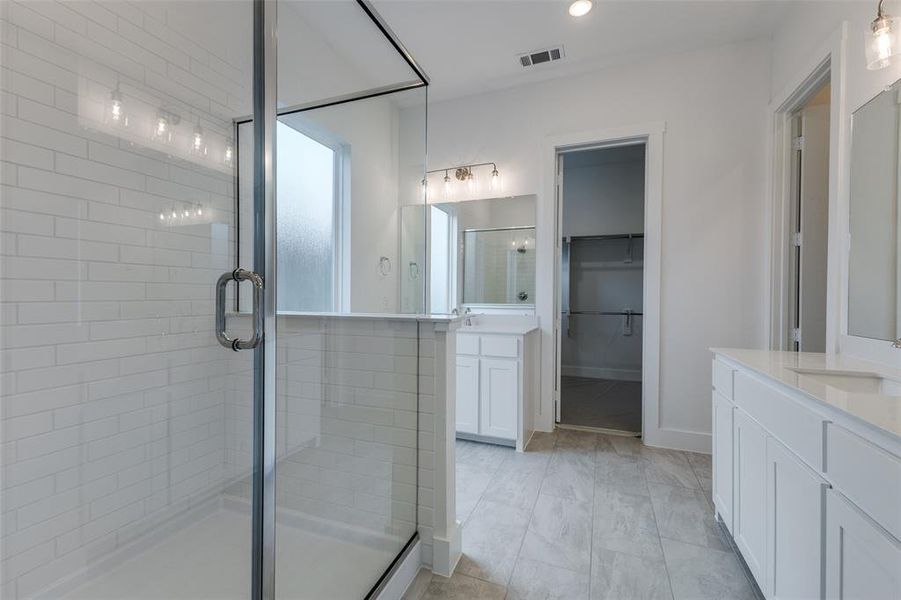 Bathroom with a shower with shower door, vanity, and tile patterned floors