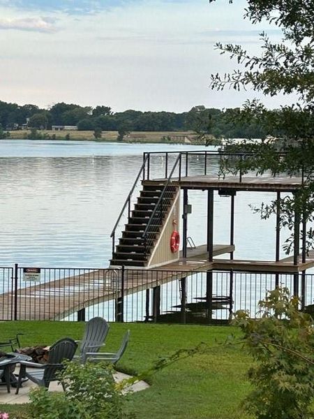 Dock area featuring a lawn and a water view