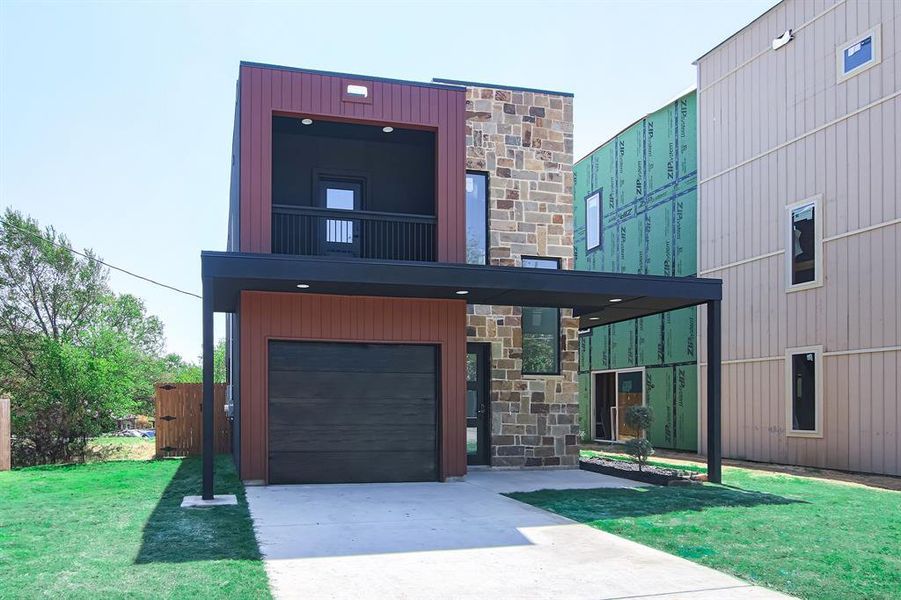 Contemporary home featuring a garage and a front yard