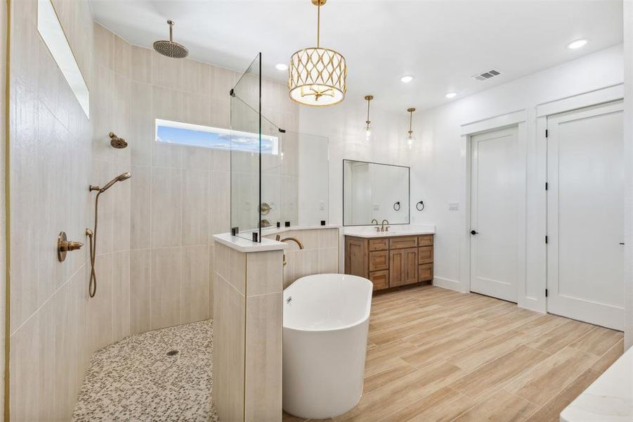 Bathroom featuring independent shower and bath, vanity, hardwood / wood-style flooring, and tile walls