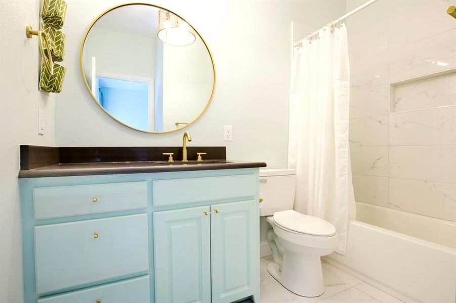 The Guest Ensuite Bath with Gold Fixtures and Beachy Vanity Paint Color