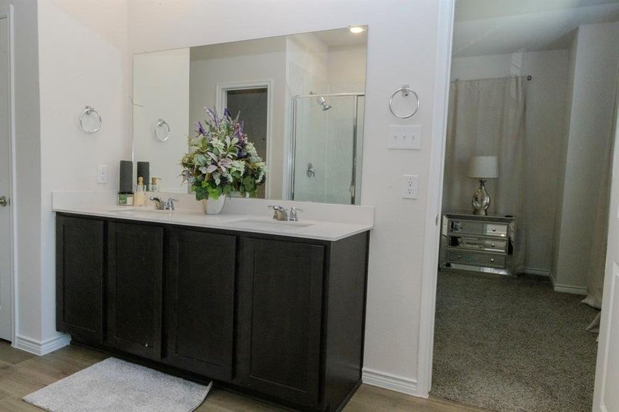 Bathroom with vanity, hardwood / wood-style floors, and an enclosed shower