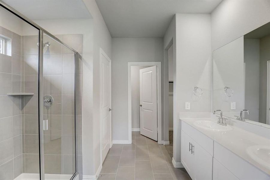 Bathroom featuring walk in shower, vanity, and tile patterned floors