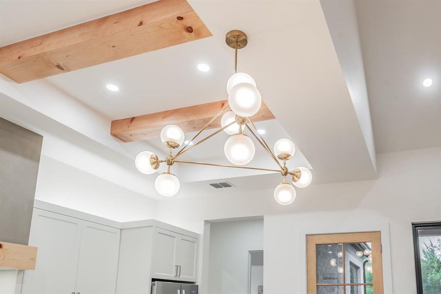 Interior details with beamed ceiling, fridge, and a chandelier