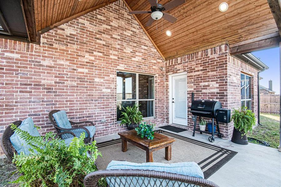 View of patio with area for grilling and ceiling fan