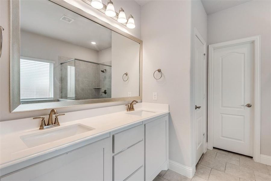 Bathroom with tile patterned floors, walk in shower, and vanity