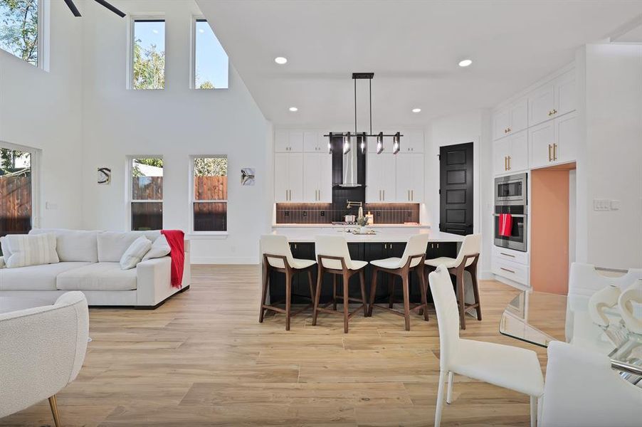 Kitchen with plenty of natural light, an island with sink, hanging light fixtures, and stainless steel appliances