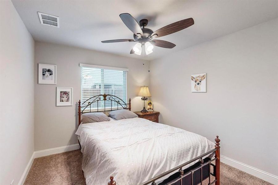 Carpeted bedroom with ceiling fan