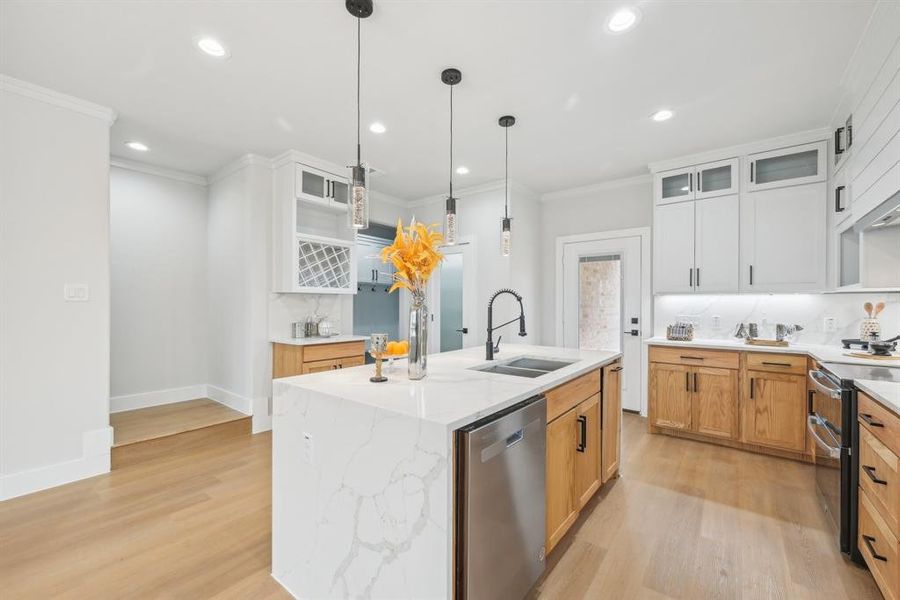 Kitchen featuring a center island with sink, appliances with stainless steel finishes, light hardwood / wood-style floors, sink, and white cabinets