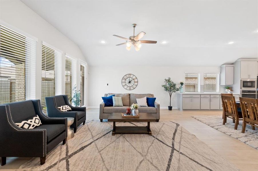 The living room features wide windows that fill the space with natural light, creating a bright and inviting atmosphere.