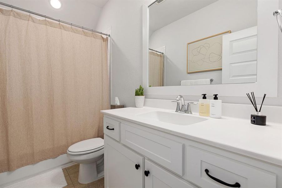 Bathroom with vanity, tile patterned floors, and toilet