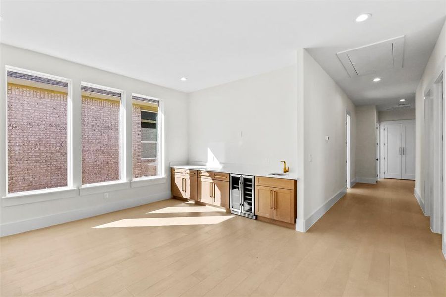 Bar featuring wine cooler and light hardwood / wood-style flooring