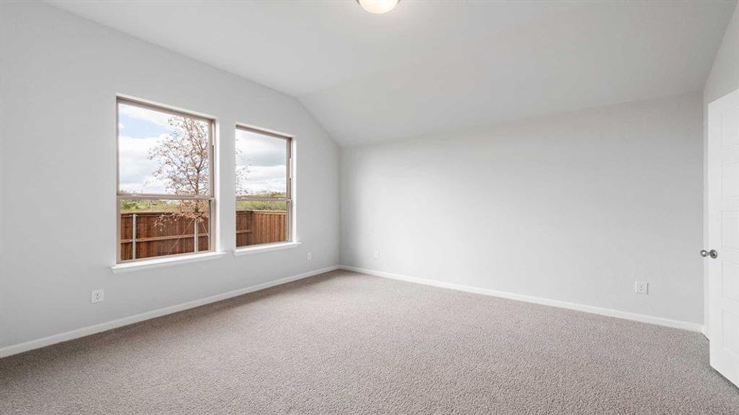 Empty room with lofted ceiling and carpet flooring