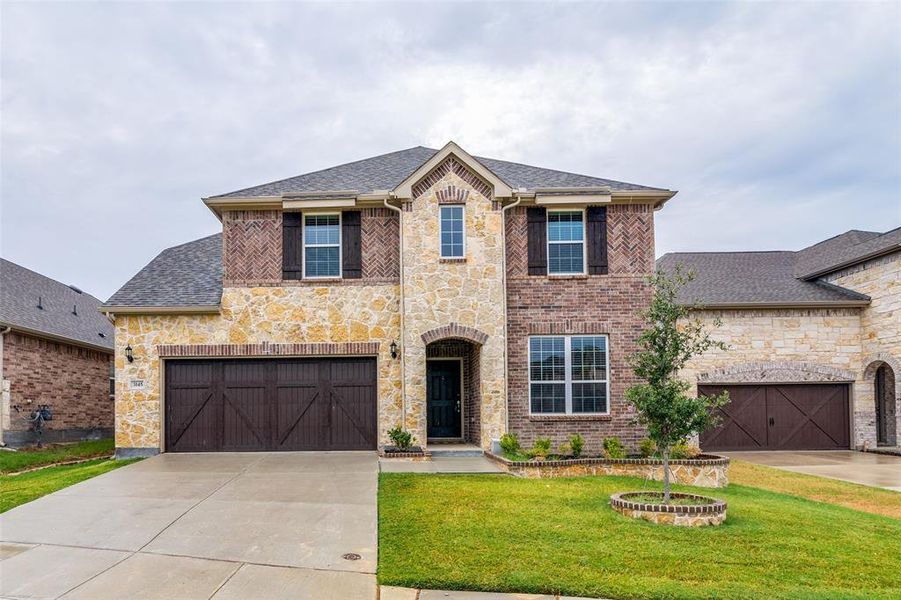 View of front of home with a garage and a front yard